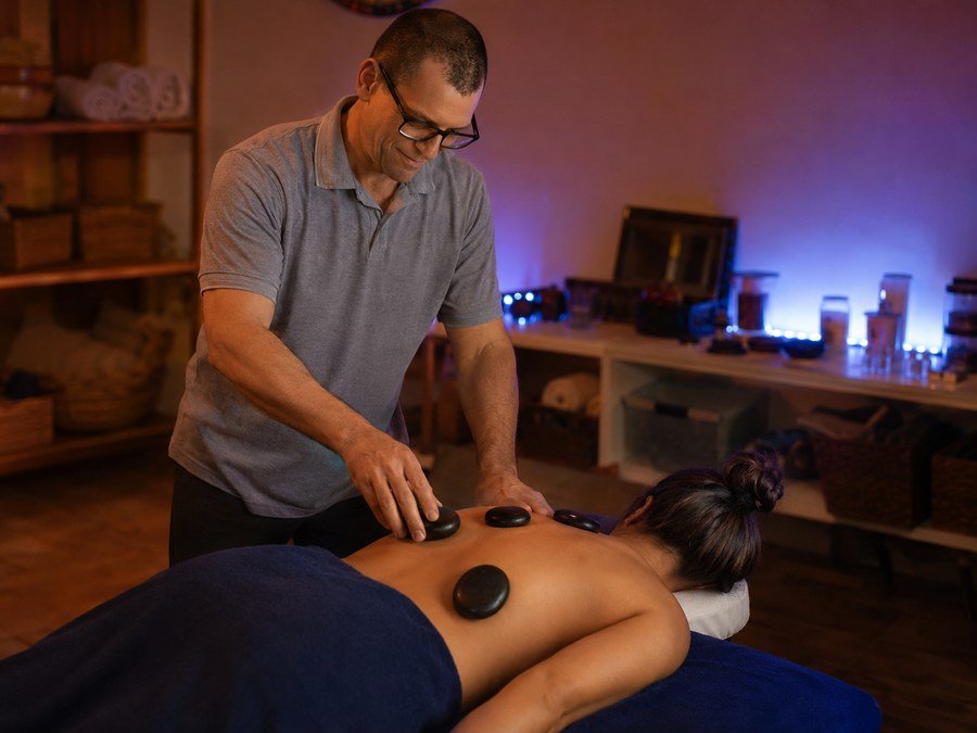 Paulo Sauer realizando massagem com pedras quentes